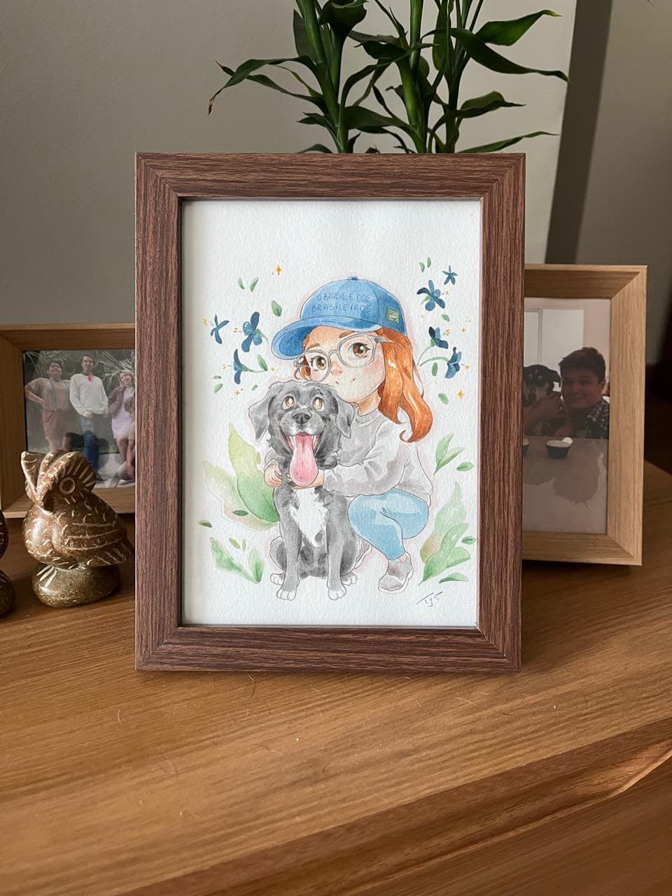 Fotografia de uma aquarela de duas pessoas com cães, gatos e flores.